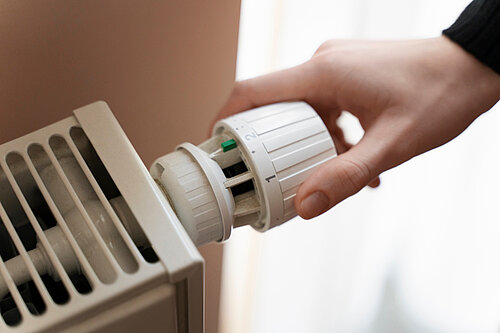 Person adjusting a radiator 