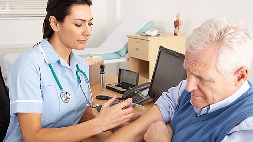 A nurse giving an injection to an old man.